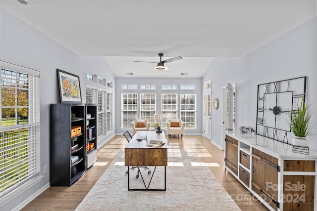 living room featuring plenty of natural light, wood-type flooring, and vaulted ceiling