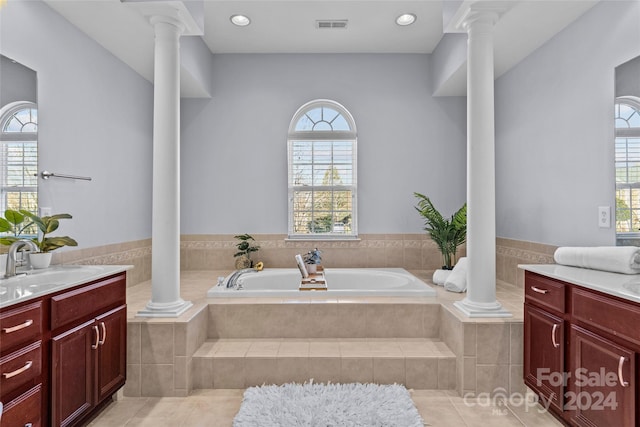 bathroom featuring tile patterned floors, tiled bath, a wealth of natural light, and vanity