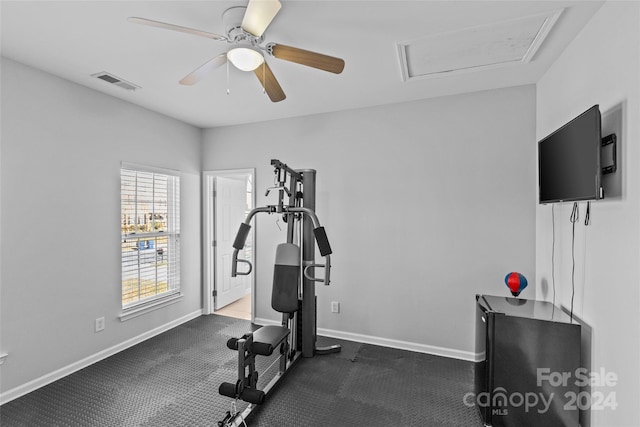 exercise room with dark carpet and ceiling fan