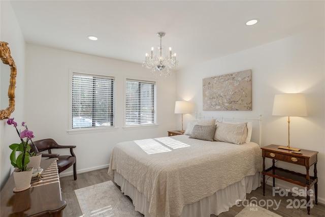 bedroom with hardwood / wood-style floors and a notable chandelier