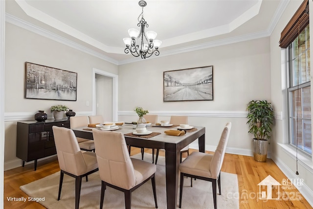 dining room featuring plenty of natural light, a tray ceiling, and light hardwood / wood-style flooring