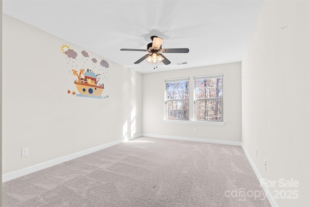 carpeted spare room featuring ceiling fan