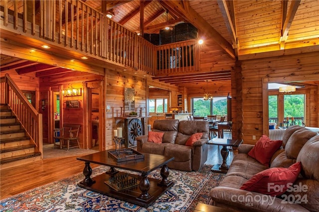 living room with hardwood / wood-style floors, high vaulted ceiling, wooden walls, and a wealth of natural light