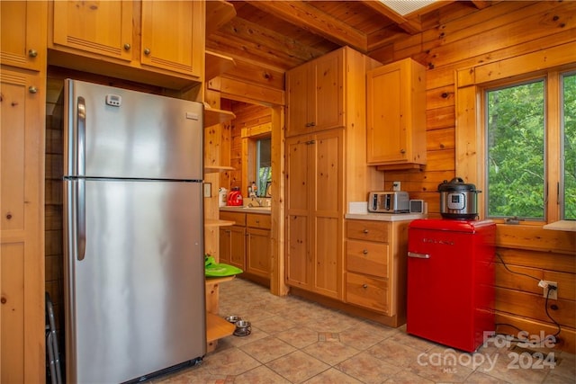 kitchen featuring wooden walls, stainless steel fridge, beam ceiling, light tile patterned flooring, and wood ceiling