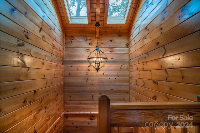 interior space featuring a skylight and wooden walls