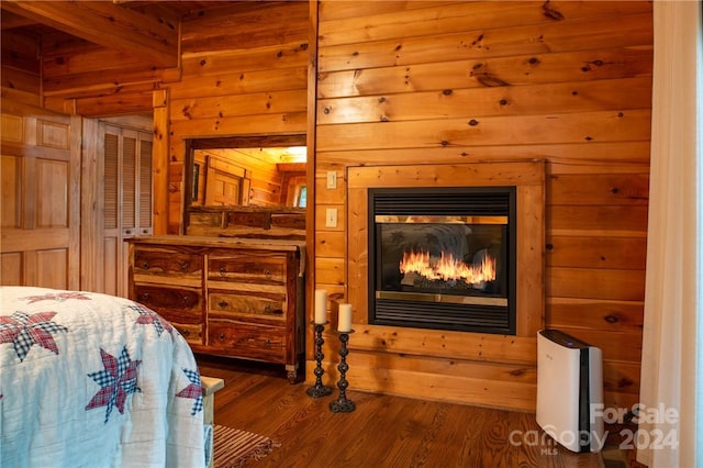 bedroom with wood walls and dark wood-type flooring