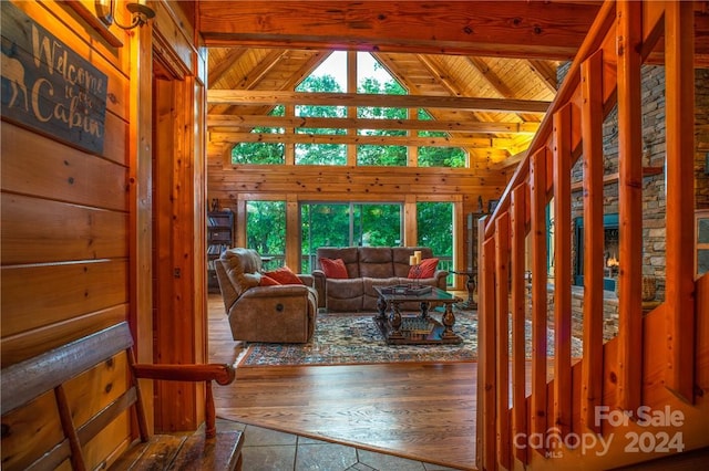 living room with lofted ceiling with beams, hardwood / wood-style flooring, plenty of natural light, and wood ceiling