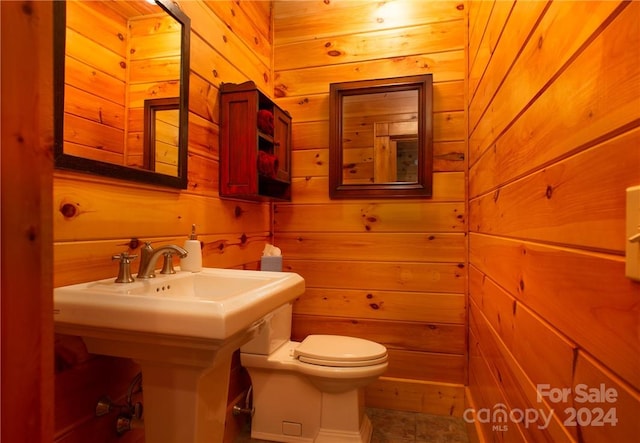 bathroom featuring toilet and wood walls