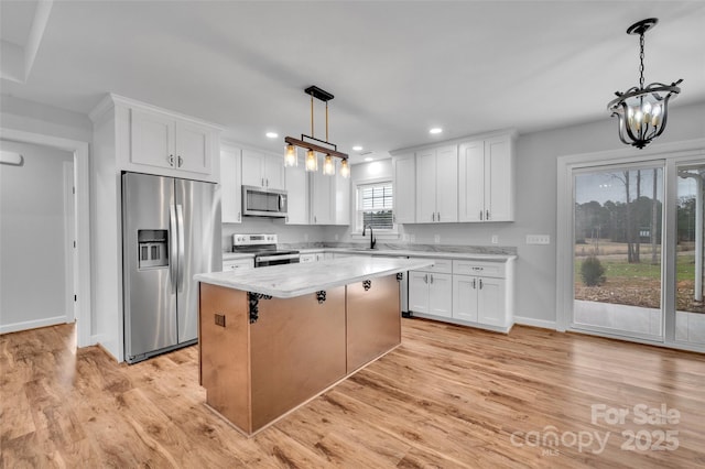 kitchen with white cabinets, light wood-style floors, appliances with stainless steel finishes, and a center island