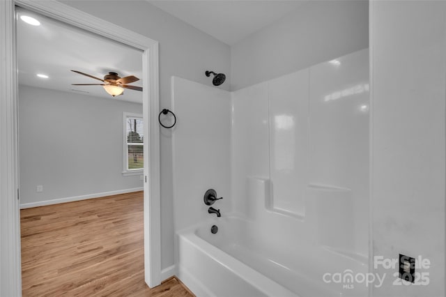 bathroom featuring tub / shower combination, a ceiling fan, baseboards, and wood finished floors