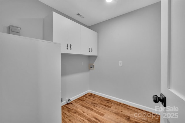 laundry room featuring light wood-type flooring, visible vents, washer hookup, cabinet space, and baseboards