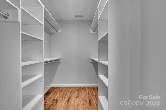 spacious closet with visible vents and wood finished floors