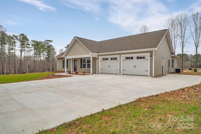 ranch-style home with cooling unit, concrete driveway, a garage, and roof with shingles