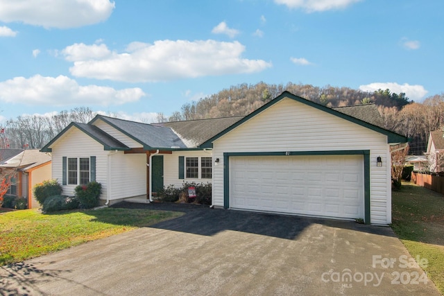 ranch-style house with a garage and a front lawn