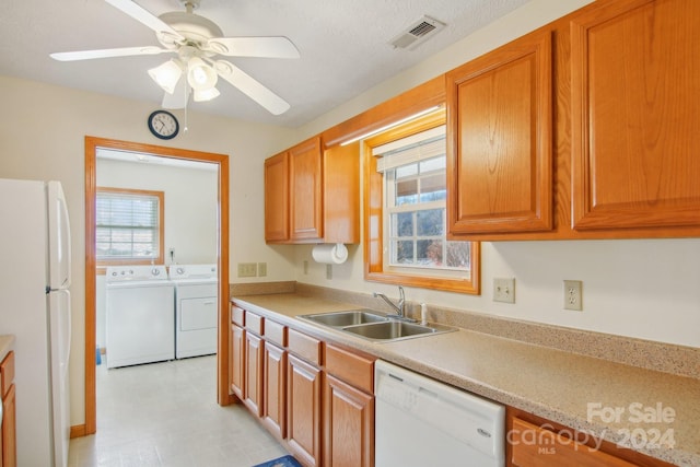 kitchen featuring ceiling fan, washing machine and dryer, white appliances, and sink