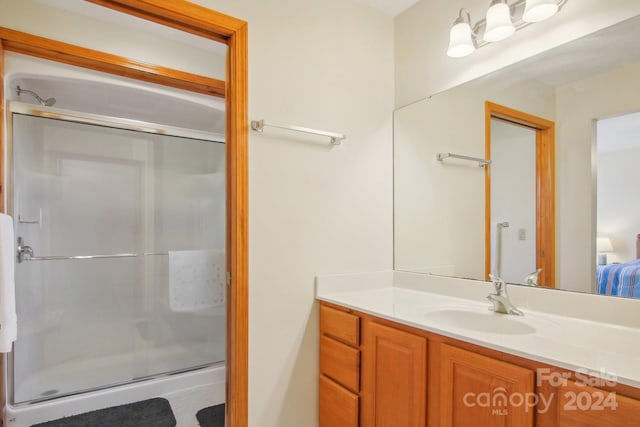 bathroom featuring vanity and a shower with door