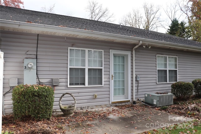 view of side of property featuring central air condition unit and a patio