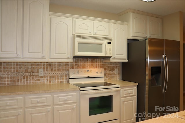 kitchen featuring decorative backsplash, white appliances, and white cabinetry