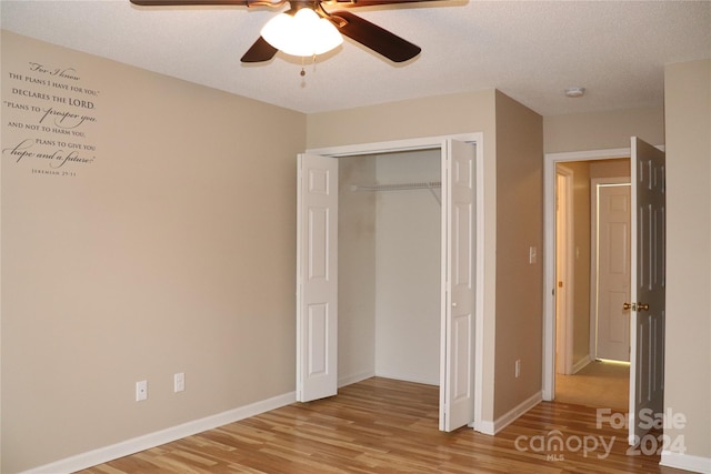 unfurnished bedroom with hardwood / wood-style floors, ceiling fan, a textured ceiling, and a closet