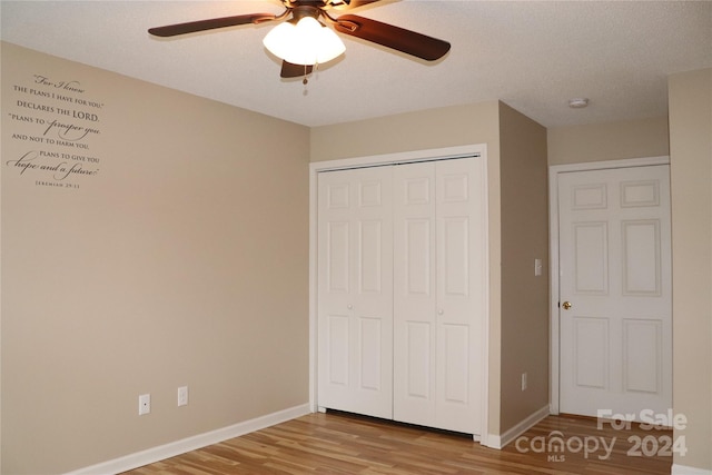 unfurnished bedroom with hardwood / wood-style floors, a textured ceiling, a closet, and ceiling fan