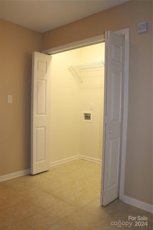 washroom with light tile patterned flooring and hookup for a washing machine