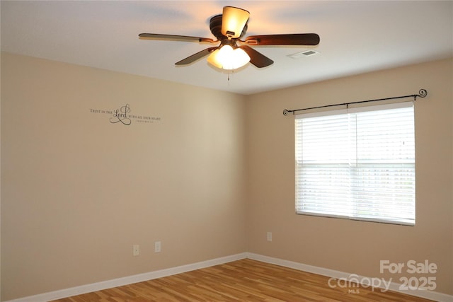 unfurnished room with baseboards, visible vents, light wood-style floors, and a ceiling fan