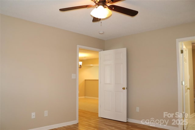unfurnished bedroom featuring baseboards, a ceiling fan, and light wood-type flooring