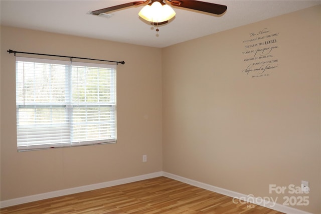empty room featuring baseboards, visible vents, light wood-style flooring, and a ceiling fan