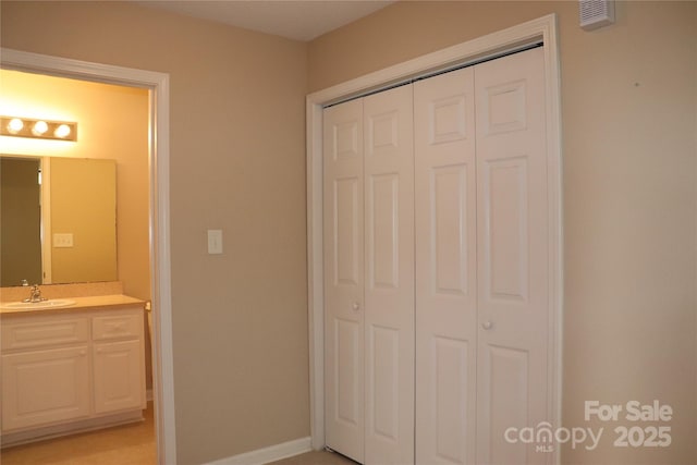 unfurnished bedroom featuring a closet, baseboards, visible vents, and a sink