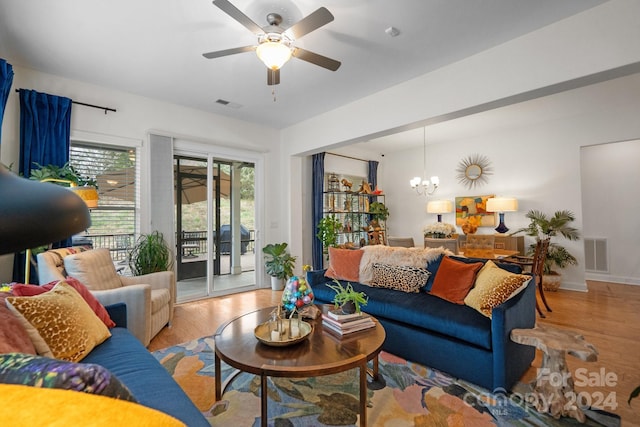 living room featuring light hardwood / wood-style floors and ceiling fan with notable chandelier