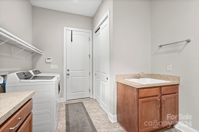 clothes washing area featuring separate washer and dryer and sink