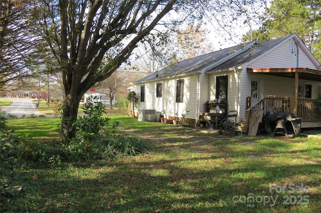 exterior space featuring cooling unit and a lawn