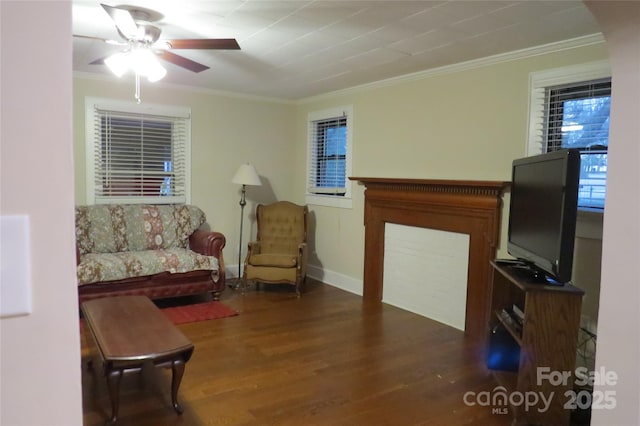 living room featuring baseboards, wood finished floors, a ceiling fan, and crown molding