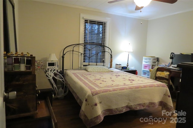 bedroom featuring ornamental molding, wood finished floors, and a ceiling fan