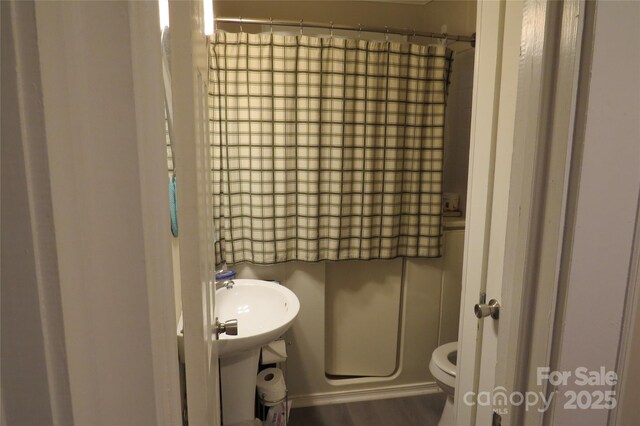 bathroom featuring a sink, wood finished floors, and toilet