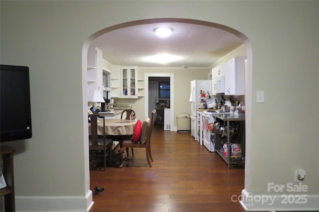 interior space featuring crown molding, arched walkways, and dark wood-type flooring