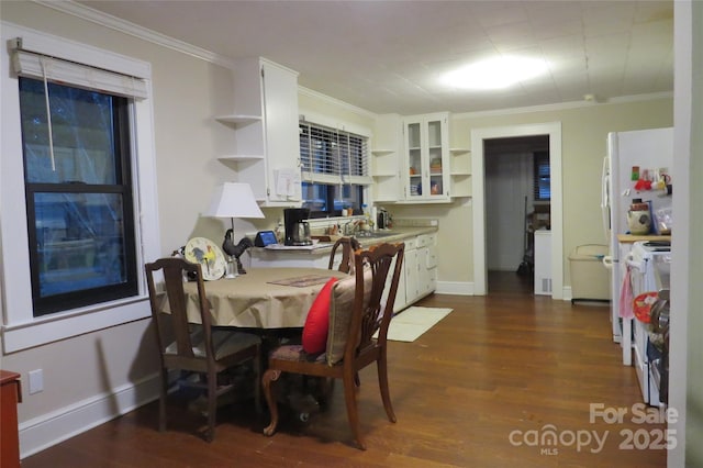 dining room featuring ornamental molding, dark wood finished floors, and baseboards