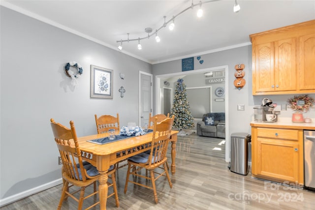 dining room with light hardwood / wood-style floors and crown molding