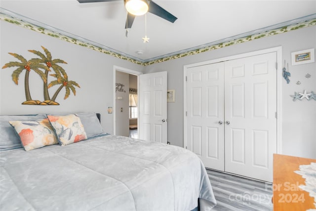 bedroom with a closet, hardwood / wood-style flooring, and ceiling fan