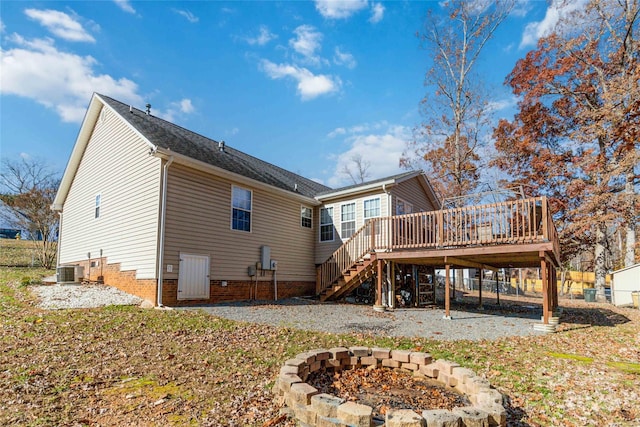 rear view of house with a fire pit, a deck, and central air condition unit