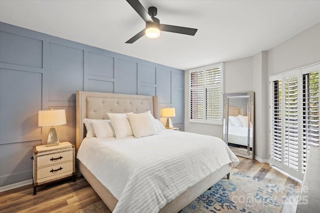 bedroom with ceiling fan, dark hardwood / wood-style flooring, and multiple windows