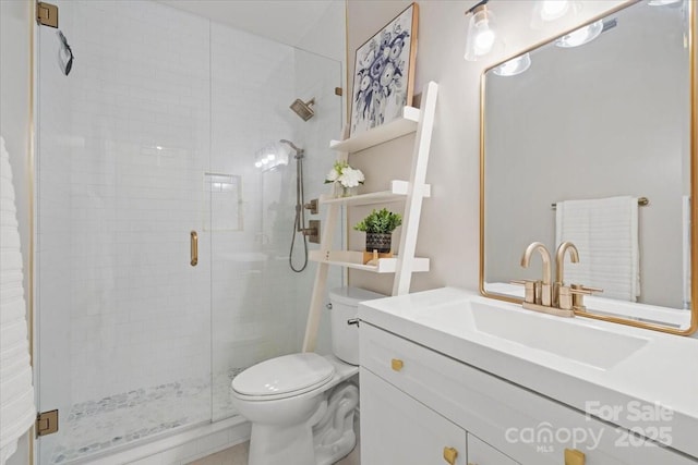 bathroom with a shower with door, vanity, and toilet