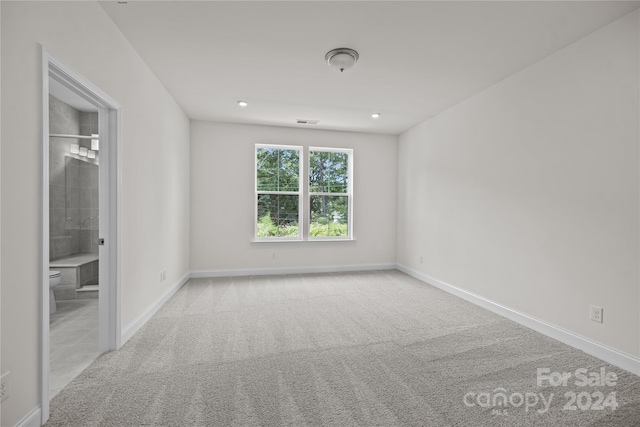 unfurnished room featuring light carpet