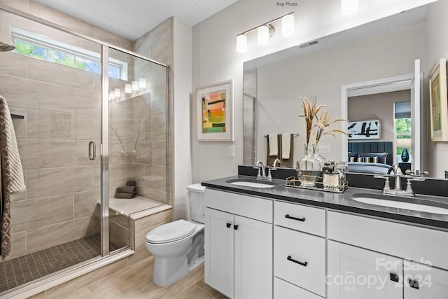 bathroom with tile patterned flooring, vanity, toilet, and a shower with shower door