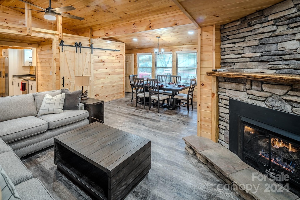 living room with a barn door, ceiling fan, wooden ceiling, and dark hardwood / wood-style floors