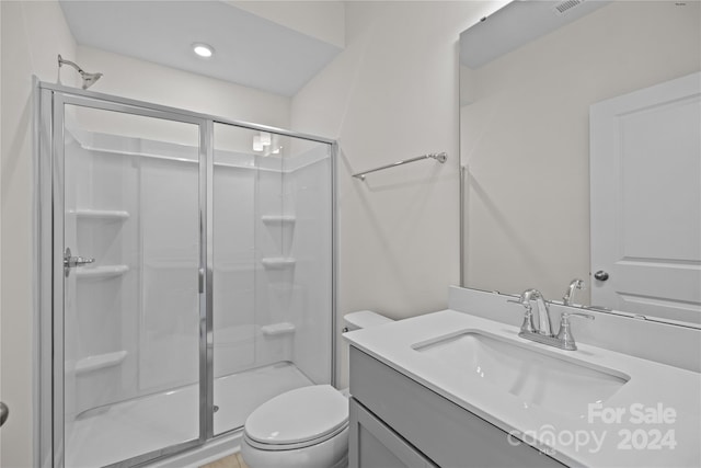 bathroom featuring vanity, an enclosed shower, and toilet