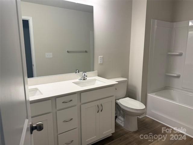 full bathroom featuring wood-type flooring, vanity, toilet, and  shower combination