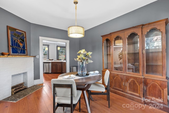 dining area featuring a brick fireplace and hardwood / wood-style flooring