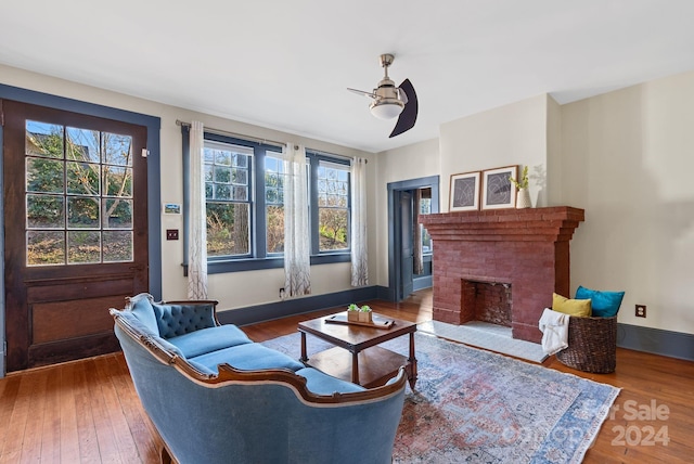 living room with hardwood / wood-style flooring, ceiling fan, a healthy amount of sunlight, and a fireplace