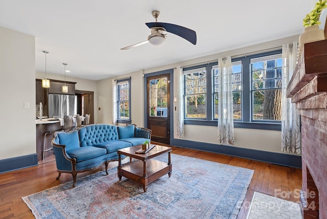 living room featuring a wealth of natural light, ceiling fan, and dark hardwood / wood-style floors